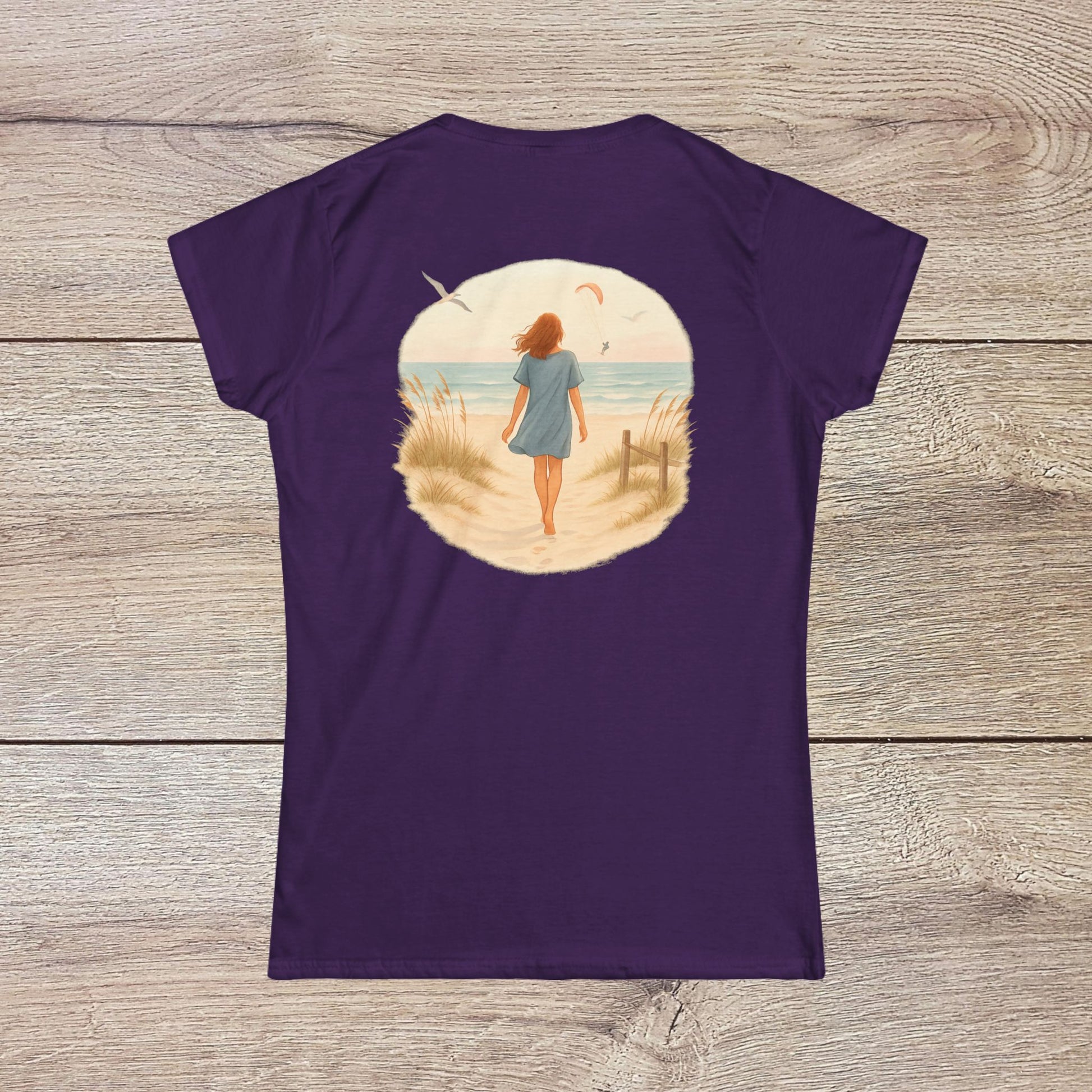Women's Coastal Spirit Midweight Cotton Tee in purple, featuring a picturesque beach design on the back, perfect for nature enthusiasts.