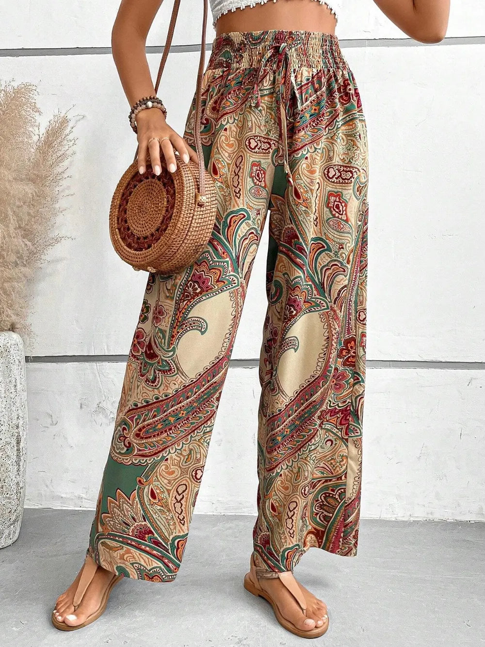 Trendy Printed Wide Leg Pants with Tied Detail in paisley design, made from 100% opaque polyester, styled with a cropped top and accessories, perfect for every occasion.