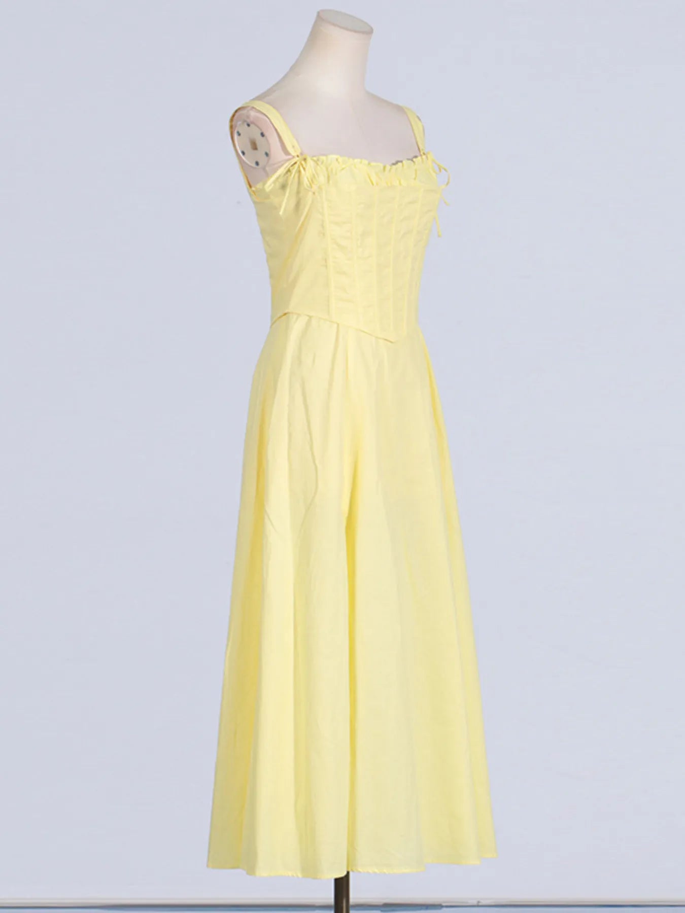 Trendy Slit Sleeveless Midi Dress with Zip Back in yellow, showcasing a side view with tied frill details and flowing skirt, made from 100% polyester.