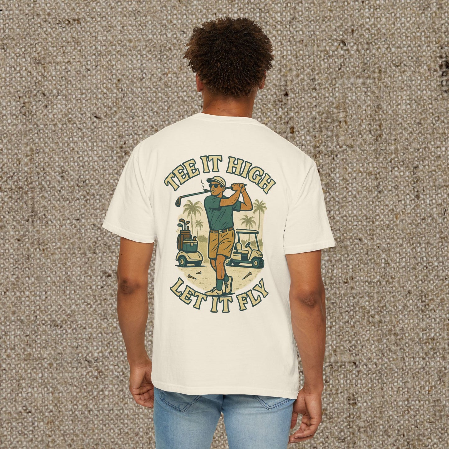 Back view of the Tee It High Let It Fly Graphic Tee, depicting a golfer in action alongside a car, showcasing vibrant colors on a light t-shirt, great for golf enthusiasts.