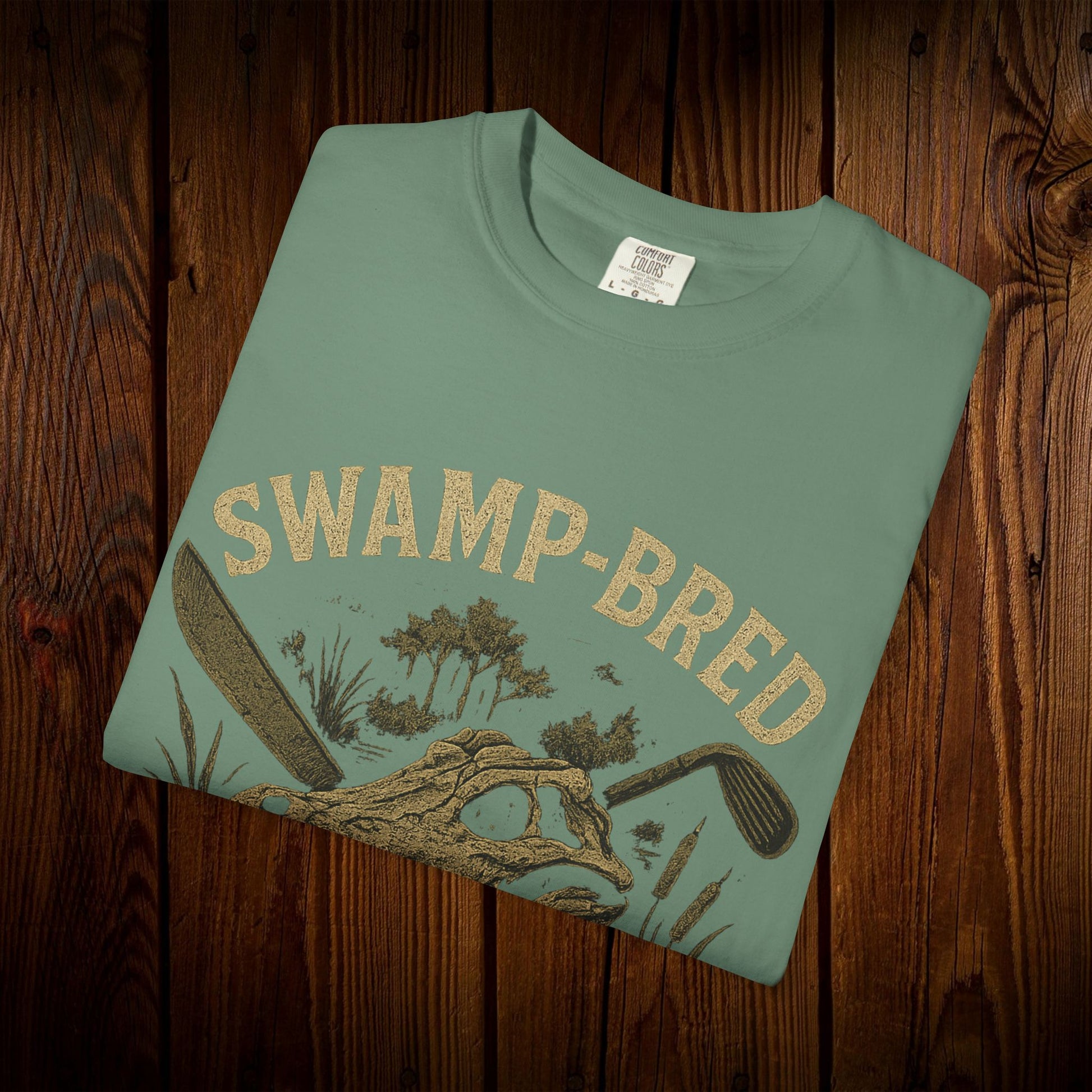 Front view of the Unisex Swamp-Bred Fairway-Fed Tee in light green, featuring an artistic swamp-inspired print, ideal for casual style.