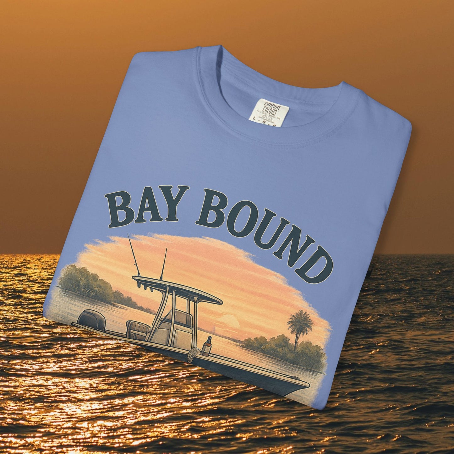 Boating T-Shirt For Summer featuring 'Bay Bound' graphic, perfect for fishing and beach lovers, laid flat against a sunset backdrop.