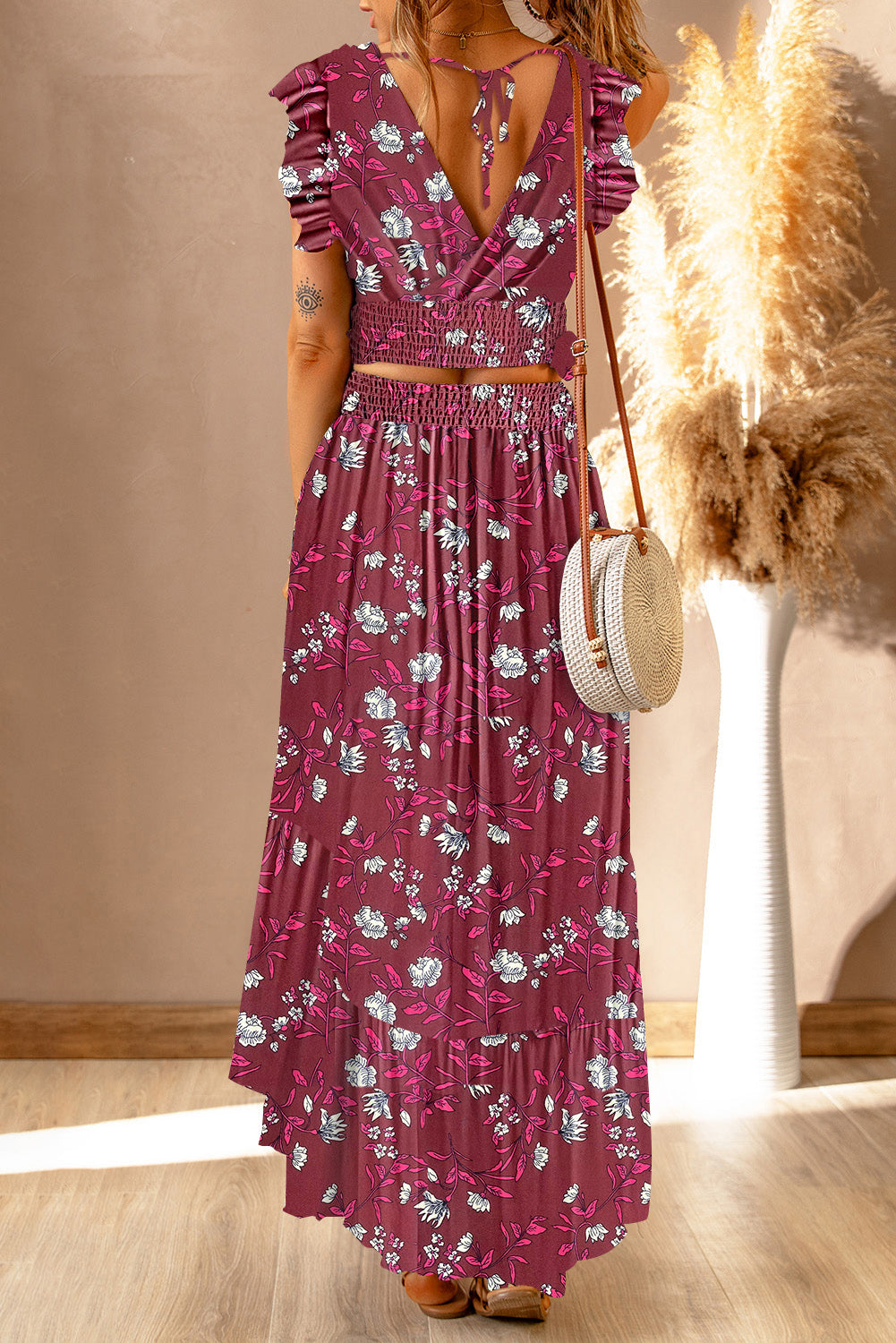 Back view of a model displaying the Floral Print Tie-Back Cropped Top & Maxi Skirt Set in a striking color scheme with unique floral patterns, perfect for warm summer days.