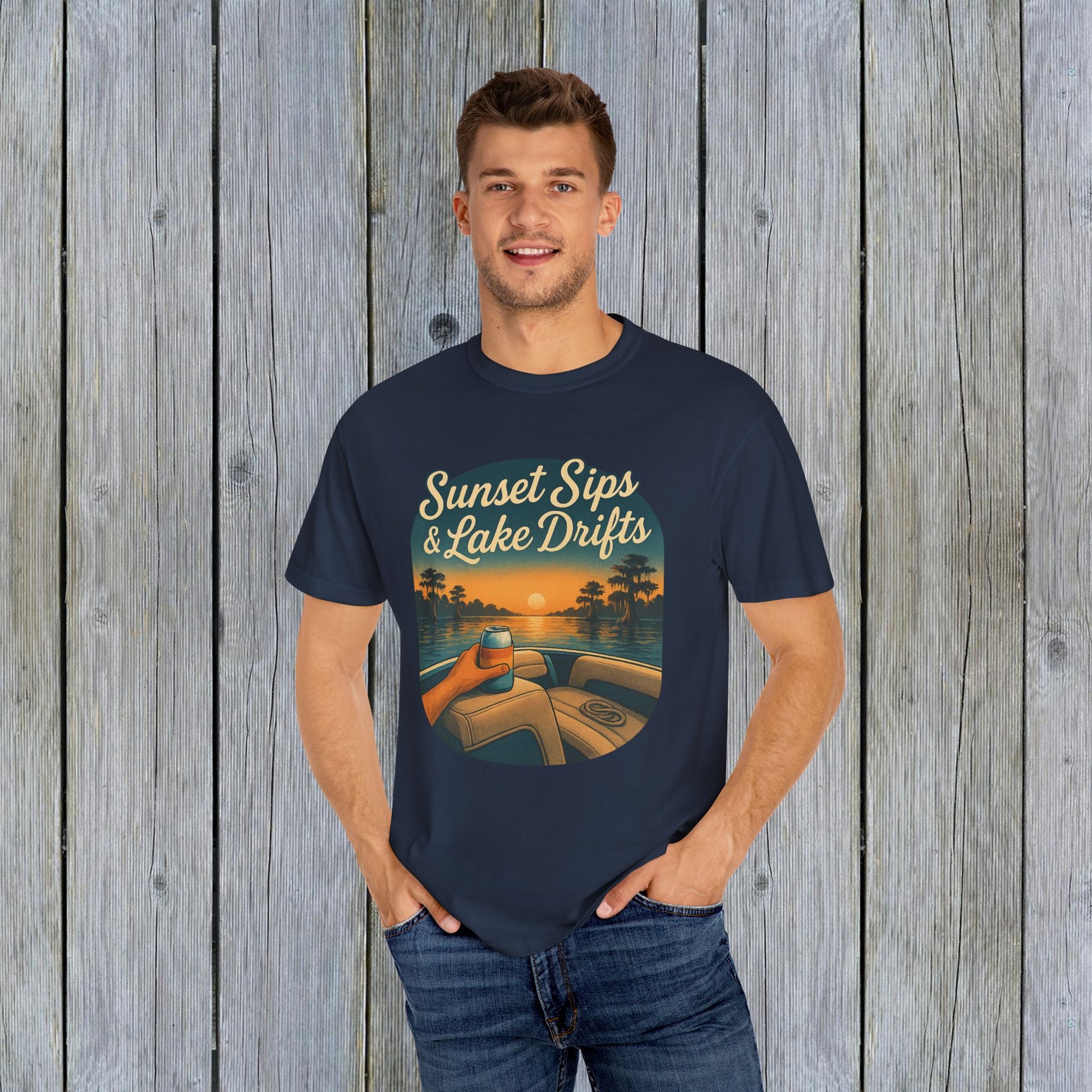 Man posing in a navy blue Lake Drifts T-Shirt with a sunset and lake design, ideal for summer adventures and lake trips.
