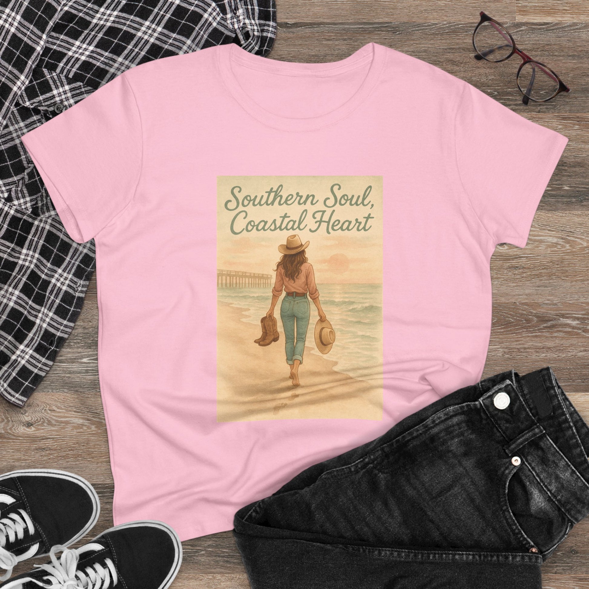 Lifestyle shot of the pink Southern Soul Coated Heart Tee laid out with black jeans and glasses, showcasing its trendy design and relaxed fit.