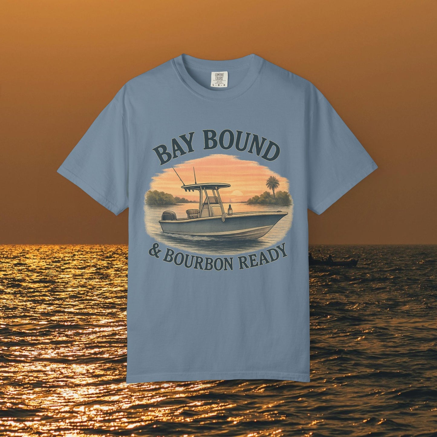 Bay Bound & Bourbon Ready T-Shirt in blue, featuring an artistic boat graphic set against a sunset, perfect for summer fishing trips.