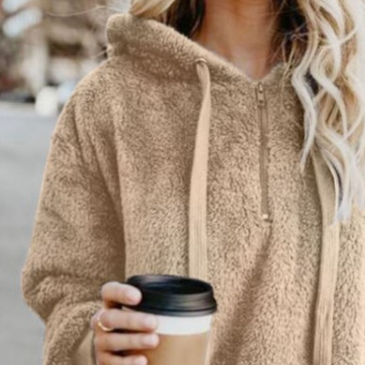 Close-up of a woman in the Cozy Full Size Teddy Hoodie with Quarter-Zip and Drawstring in beige, showcasing the hoodie and her coffee.
