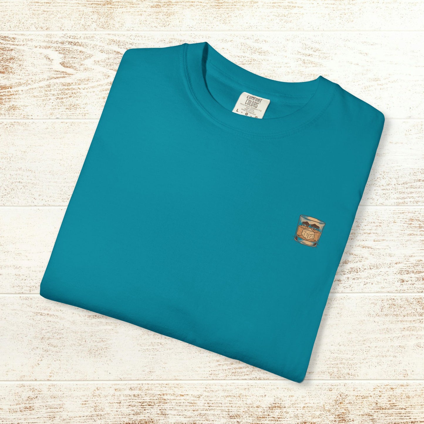 Folded Rodeo On The Rocks Tee in teal, made from soft 100% US cotton, featuring a subtle graphic on the chest, great for relaxed wear.