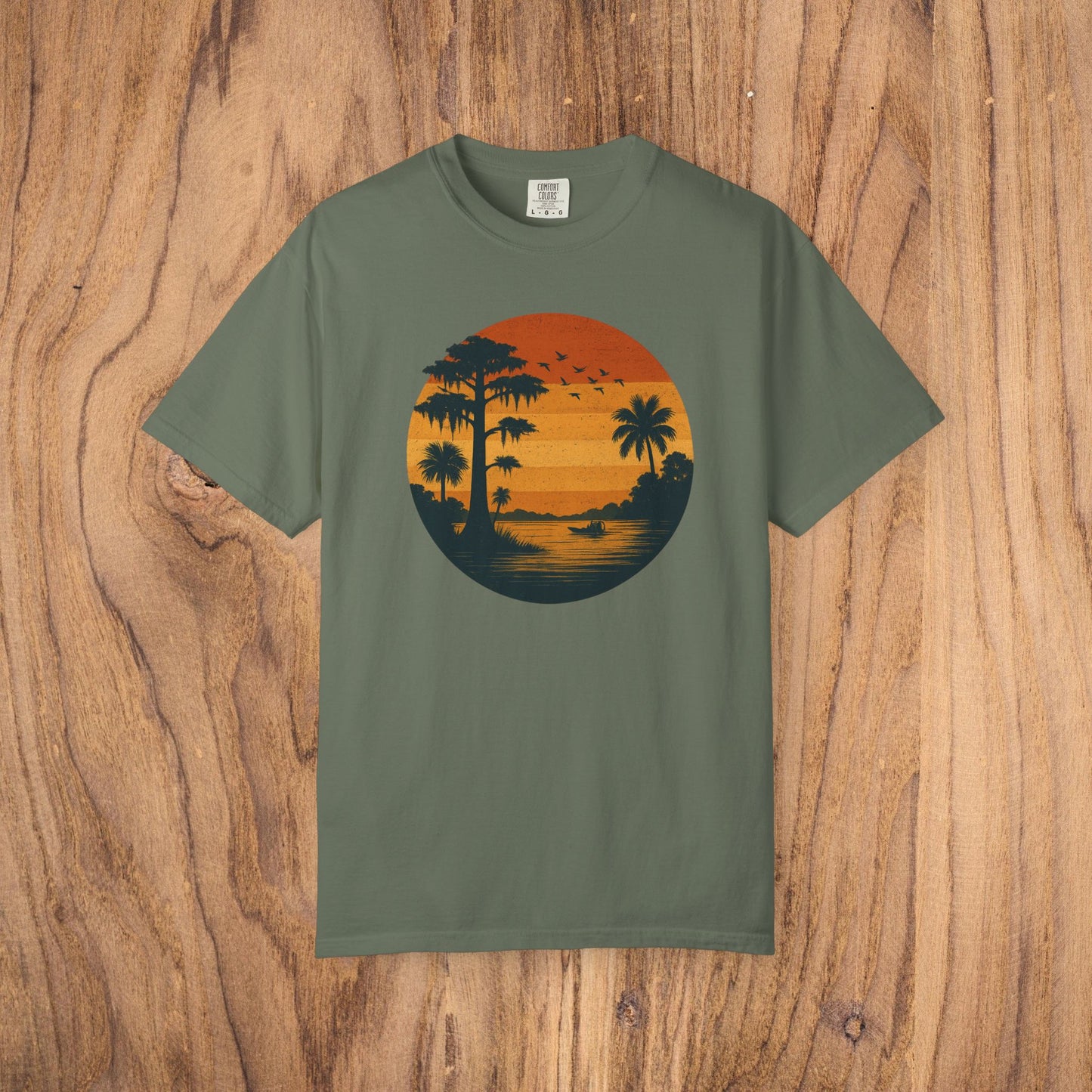 Unisex Garment-Dyed Sunset Tee in olive green featuring a vintage sunset design with palm trees, perfect for casual wear and available in sizes S to 4XL.