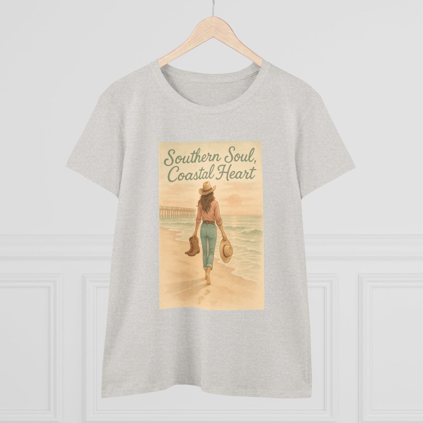 Southern Soul Coated Heart Tee on a hanger, featuring a serene coastal scene with a woman walking on the beach, showcasing a comfortable fit for unisex sizes S-3XL.