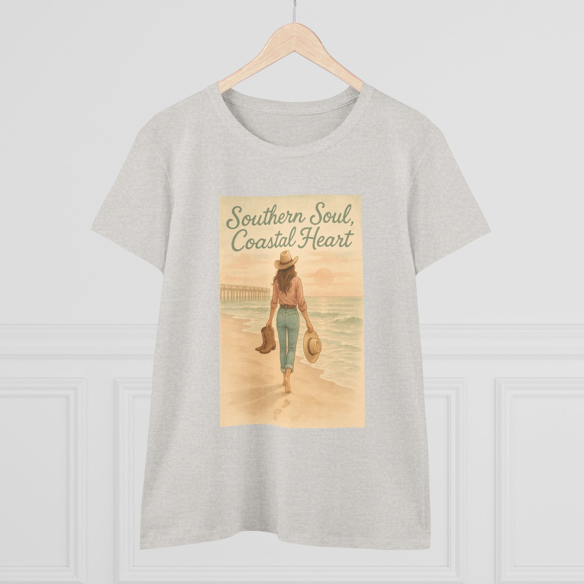 Southern Soul Coated Heart Tee on a hanger, featuring a serene coastal scene with a woman walking on the beach, showcasing a comfortable fit for unisex sizes S-3XL.
