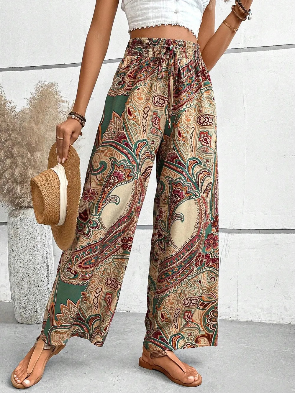 Woman wearing Trendy Printed Wide Leg Pants with Tied Detail in an elegant paisley print, paired with a stylish top, perfect for showcasing relaxed yet fashionable attire.