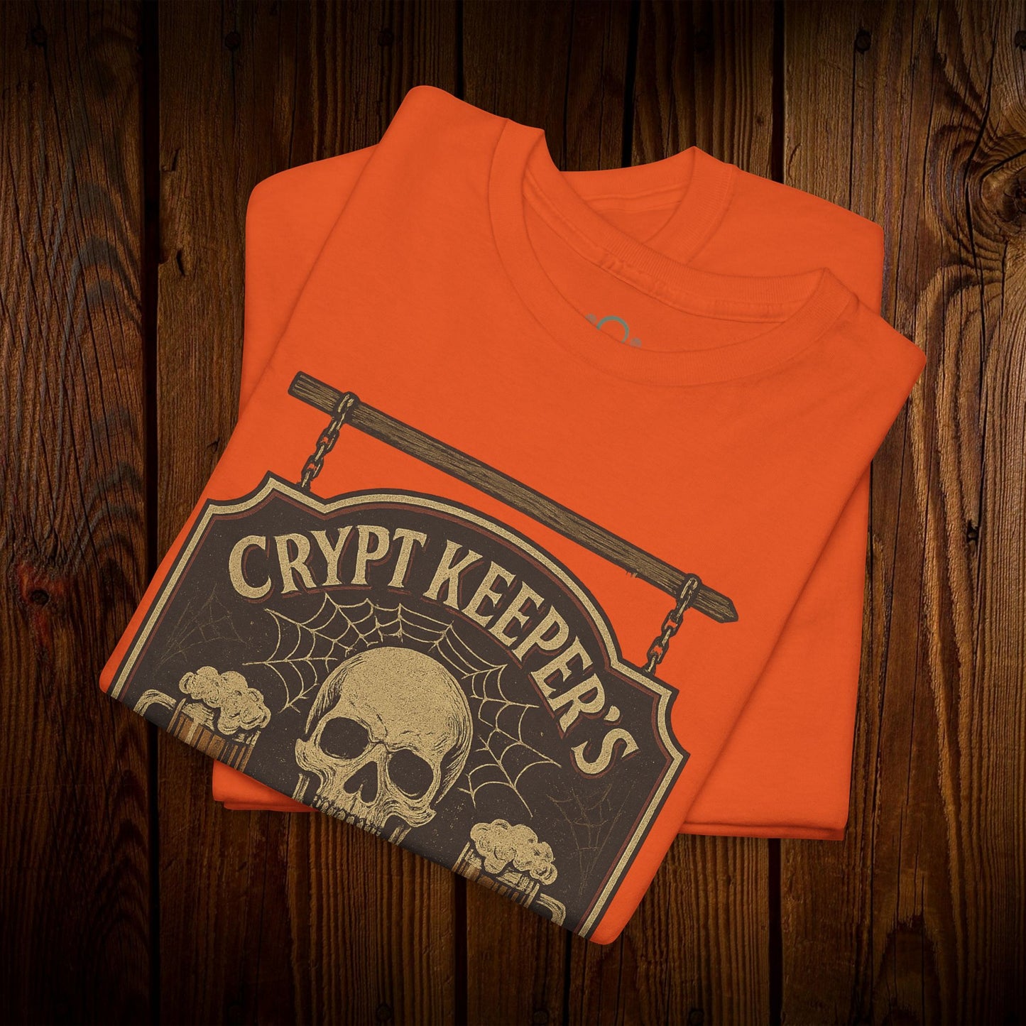 Close-up of Crypt Keeper's Pub Tee in vibrant orange, displaying a skull and beer mugs artwork, a fantastic addition for Halloween or pub crawls.