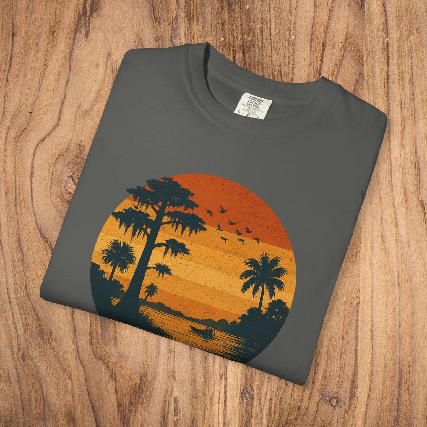 Unisex Garment-Dyed Sunset Tee in a charcoal color showcasing a stunning sunset and palm trees, crafted from 100% cotton for all-day comfort.