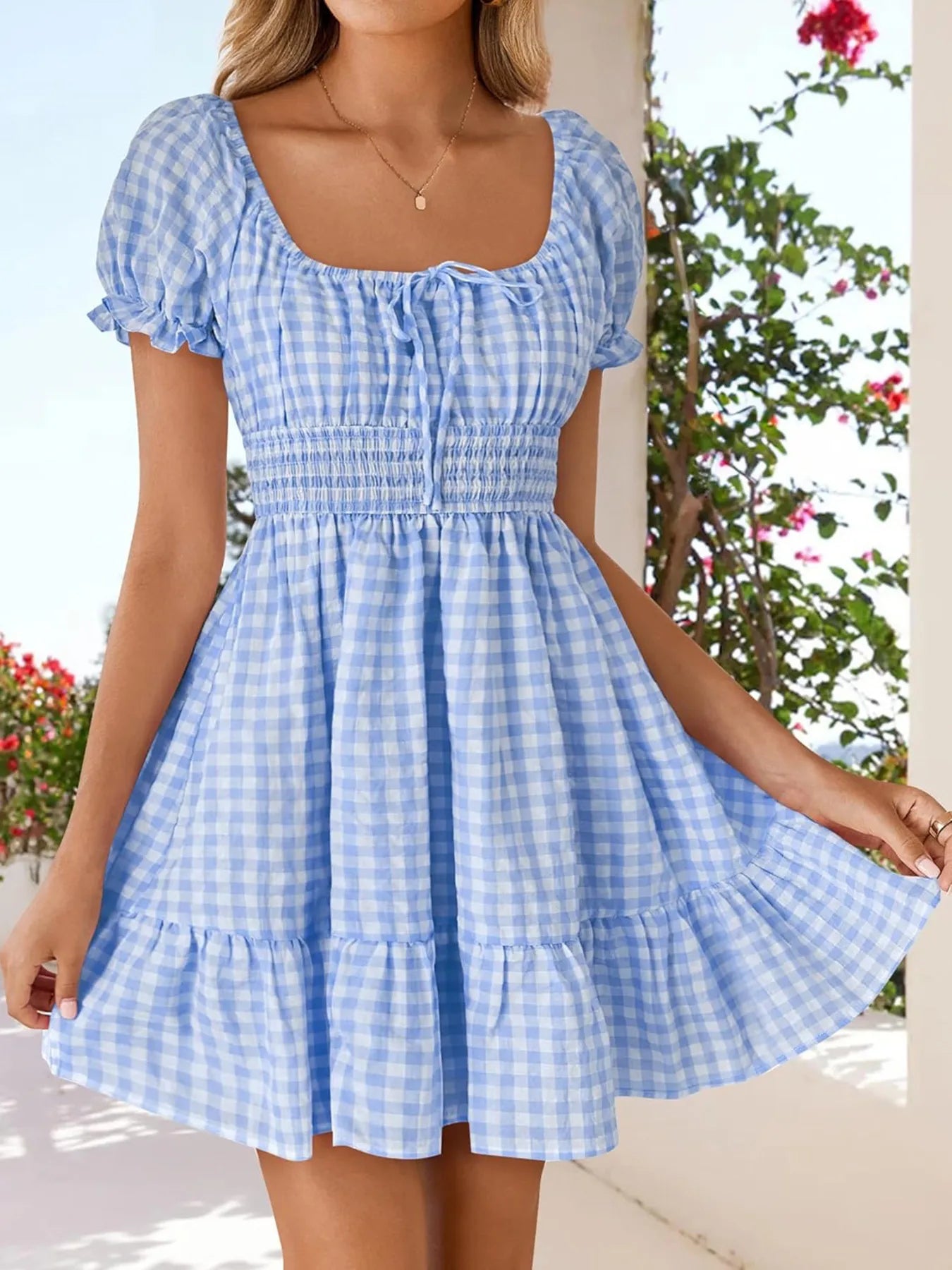 Women's Gingham Puff Sleeve Smocked Dress showcased on a model, featuring a lightweight and playful blue gingham pattern, perfect for summer outings.