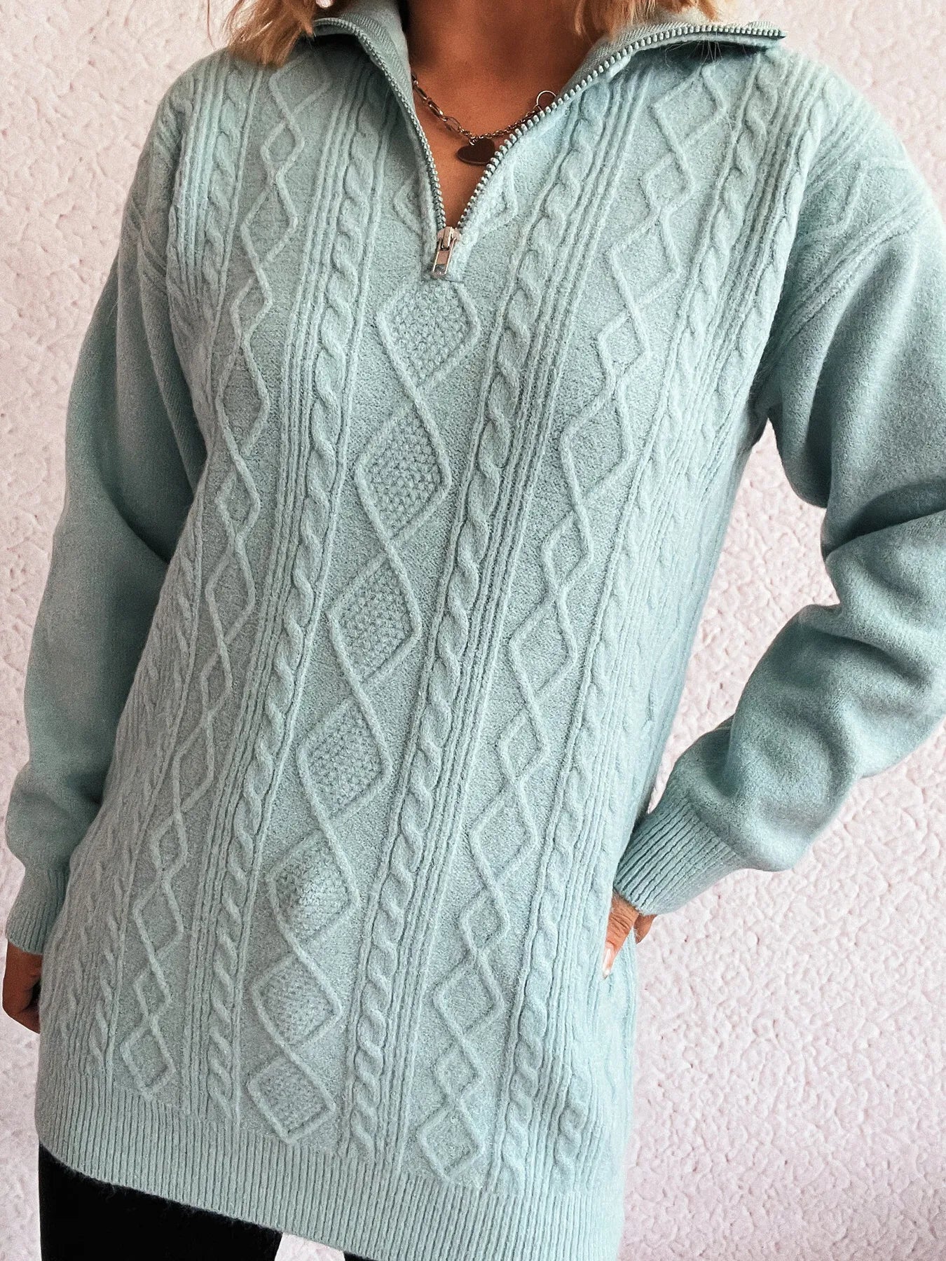 Close-up view of the Cozy Cable-Knit Texture Zip Collar Long Sleeve Sweater highlighting its intricate cable-knit design and zipper collar detail.