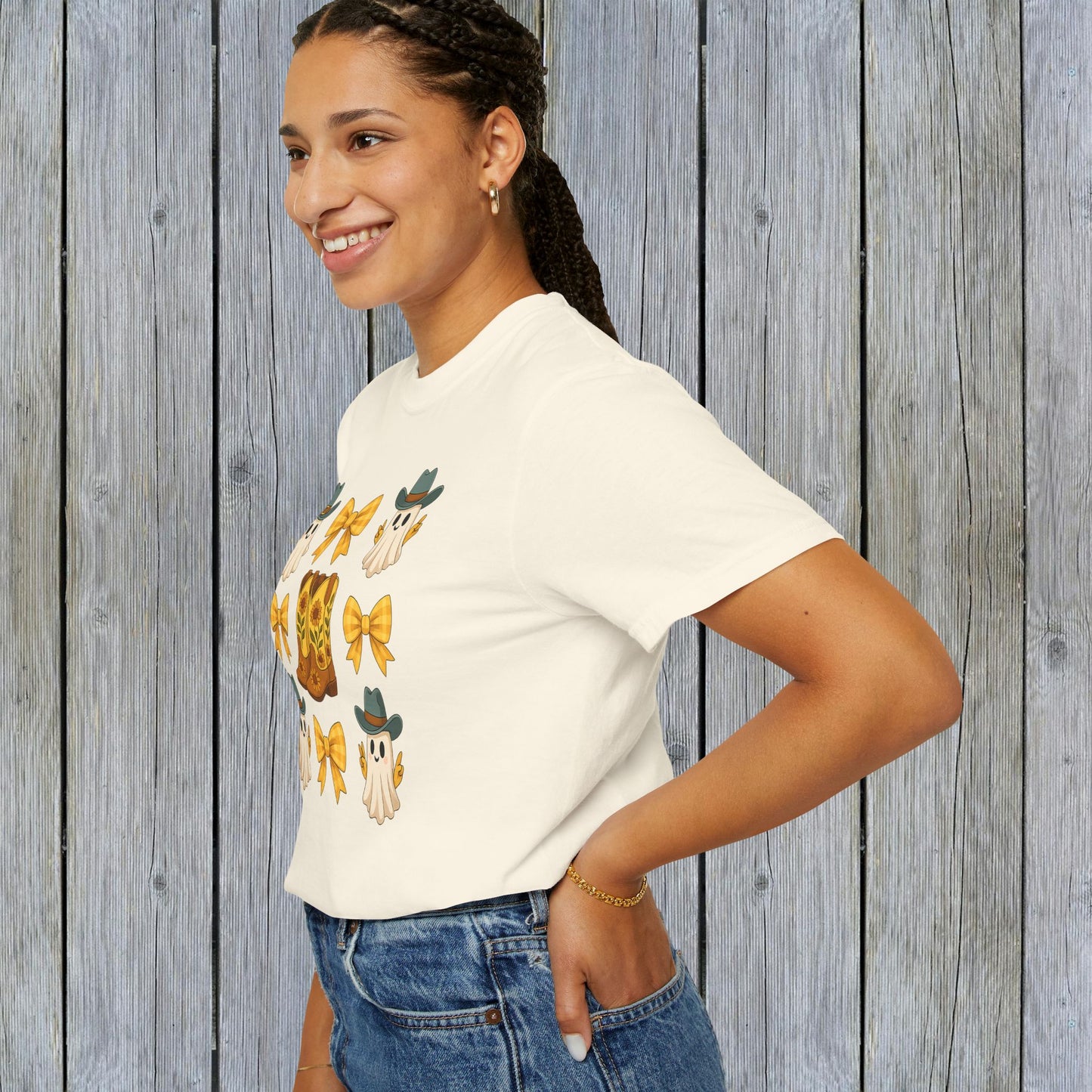 Side view of a model wearing a Cute Halloween T-Shirt with a whimsical ghosts and cowboy boots graphic, ideal for unisex fall fashion, crafted in eco-friendly material.