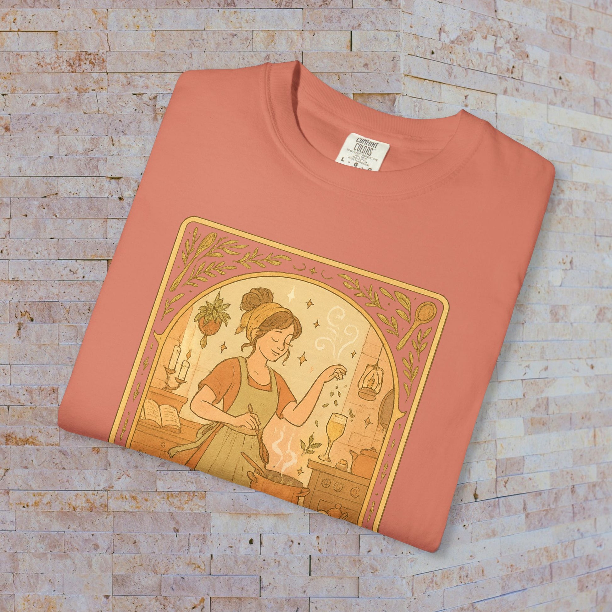Culinary Queen Tarot Tee in coral pink, highlighting a whimsical design of a woman engaged in cooking, suitable for all cooking lovers. Available in sizes S to 4XL, made from soft pre-shrunk cotton for lasting wear.