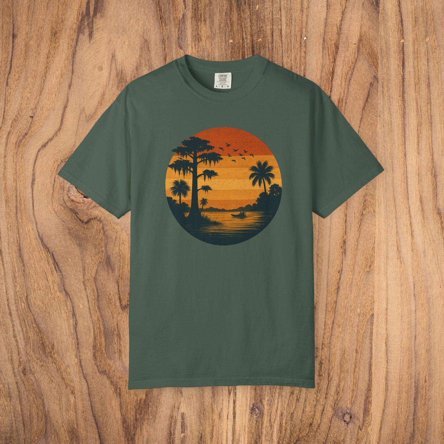 Unisex Garment-Dyed Sunset Tee in dark green featuring a serene sunset graphic with palm trees, perfect for everyday wear, available from sizes S to 4XL.