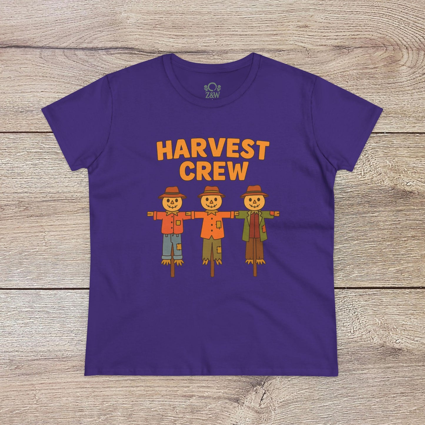 Harvest Crew Halloween T-Shirt in purple showcasing playful scarecrow illustrations alongside the phrase 'Harvest Crew'. Crafted from soft, ethical 100% ring-spun cotton, perfect for festive celebrations.