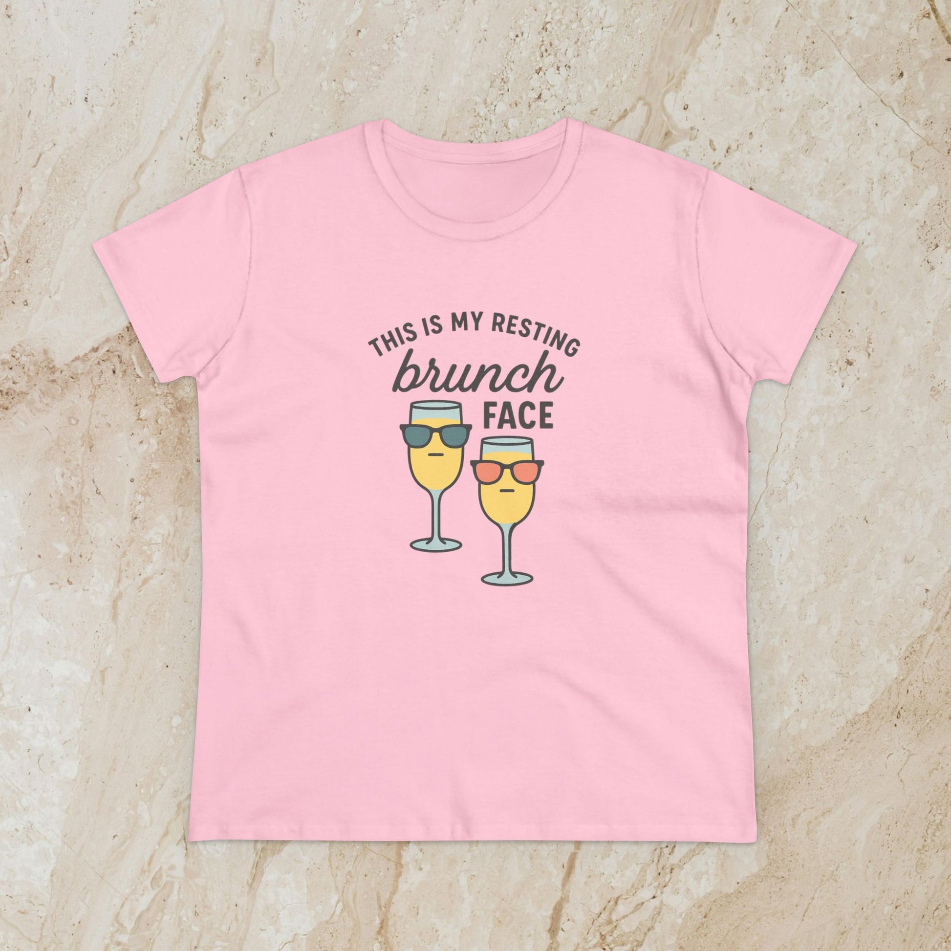 Women's Premium 100% Cotton Brunch Face Tee in light pink with a whimsical print of two cocktails with sunglasses stating 'THIS IS MY RESTING brunch FACE'. The perfect tee for stylish brunch occasions.