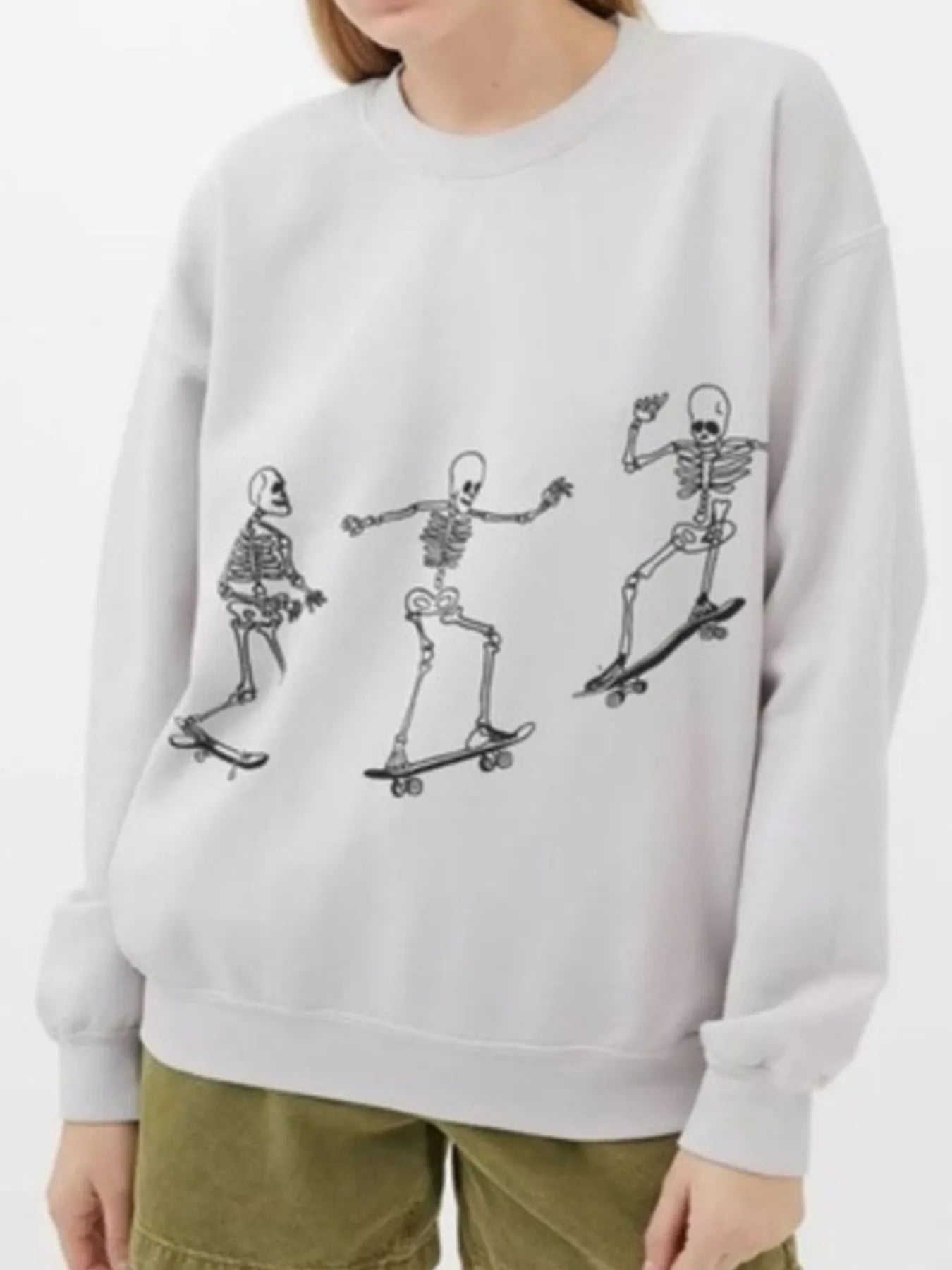Casual Oversized Skeleton Graphic Sweatshirt for Women in a light color, featuring a fun skeleton skating graphic, tailored from 100% polyester with a slightly stretchy fit.