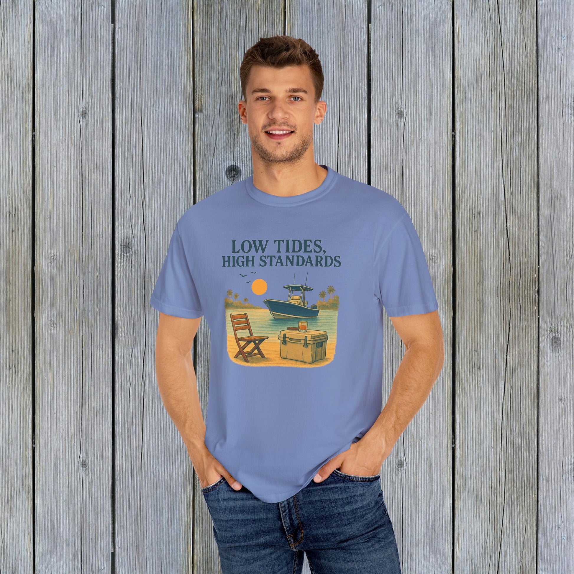 Model wearing the Garment-Dyed Low Tides High Standards T-Shirt, showcasing a boat and sunset design, perfect for casual outings, made from soft 100% US cotton.
