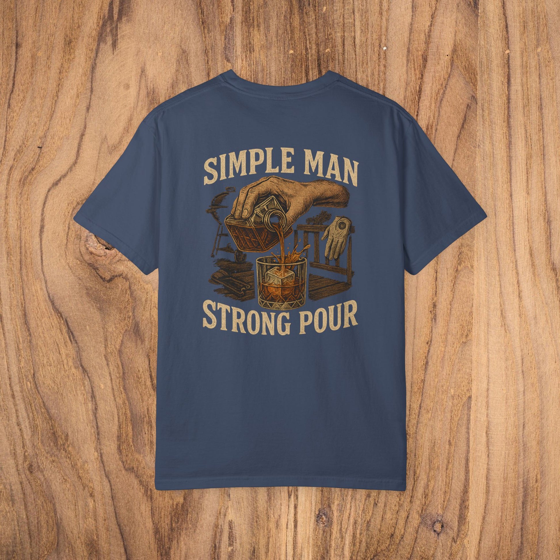 Simple Man Strong Pour T-Shirt in navy blue with an artistic illustration of a drink being poured, emphasizing classic fit and ethical material sourcing in 100% cotton for a soft feel.