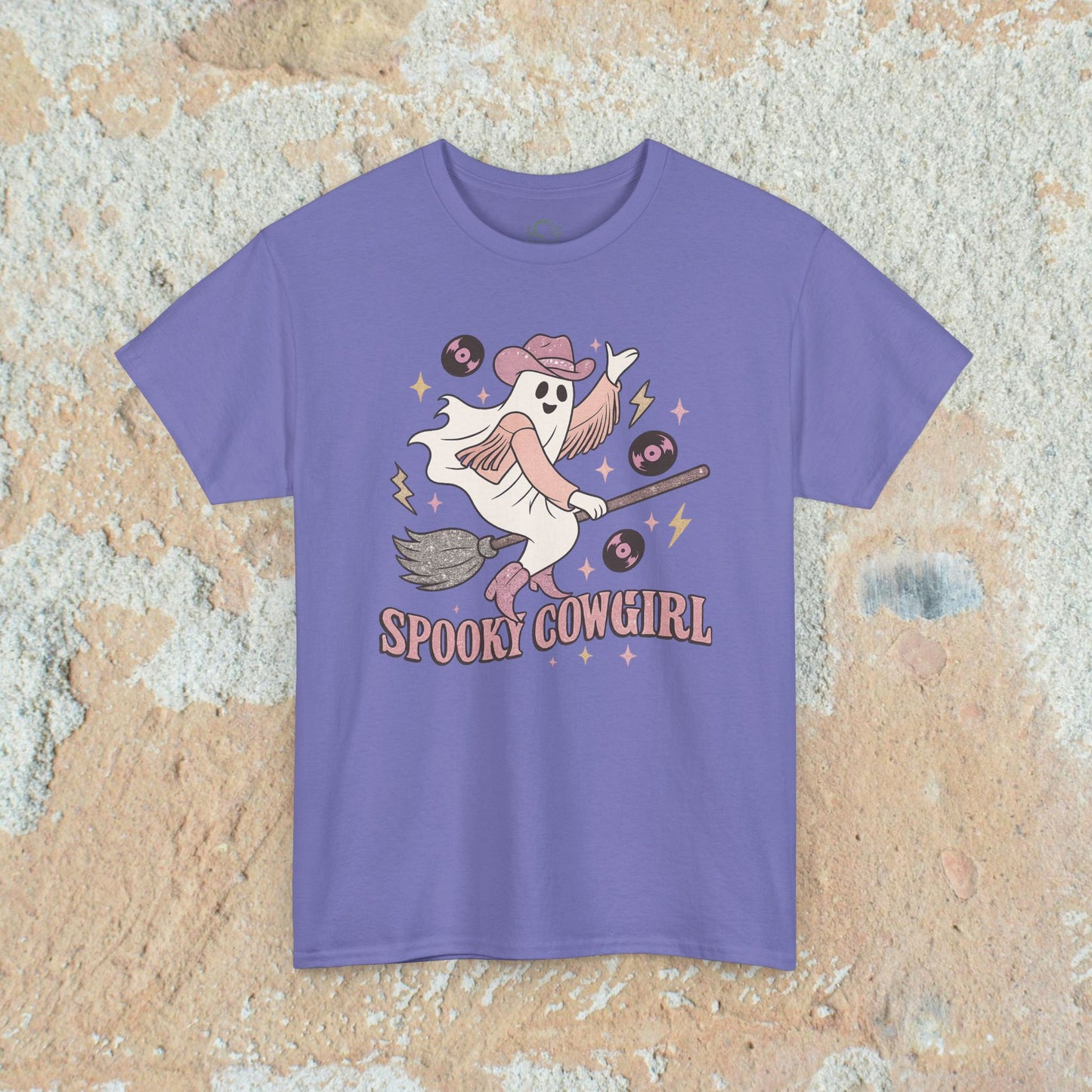 Spooky Cowgirl Graphic Tee in purple, featuring a whimsical ghost wearing a cowboy hat, riding a broomstick surrounded by vinyl records. Soft and eco-friendly fabric, available in sizes S-5XL.