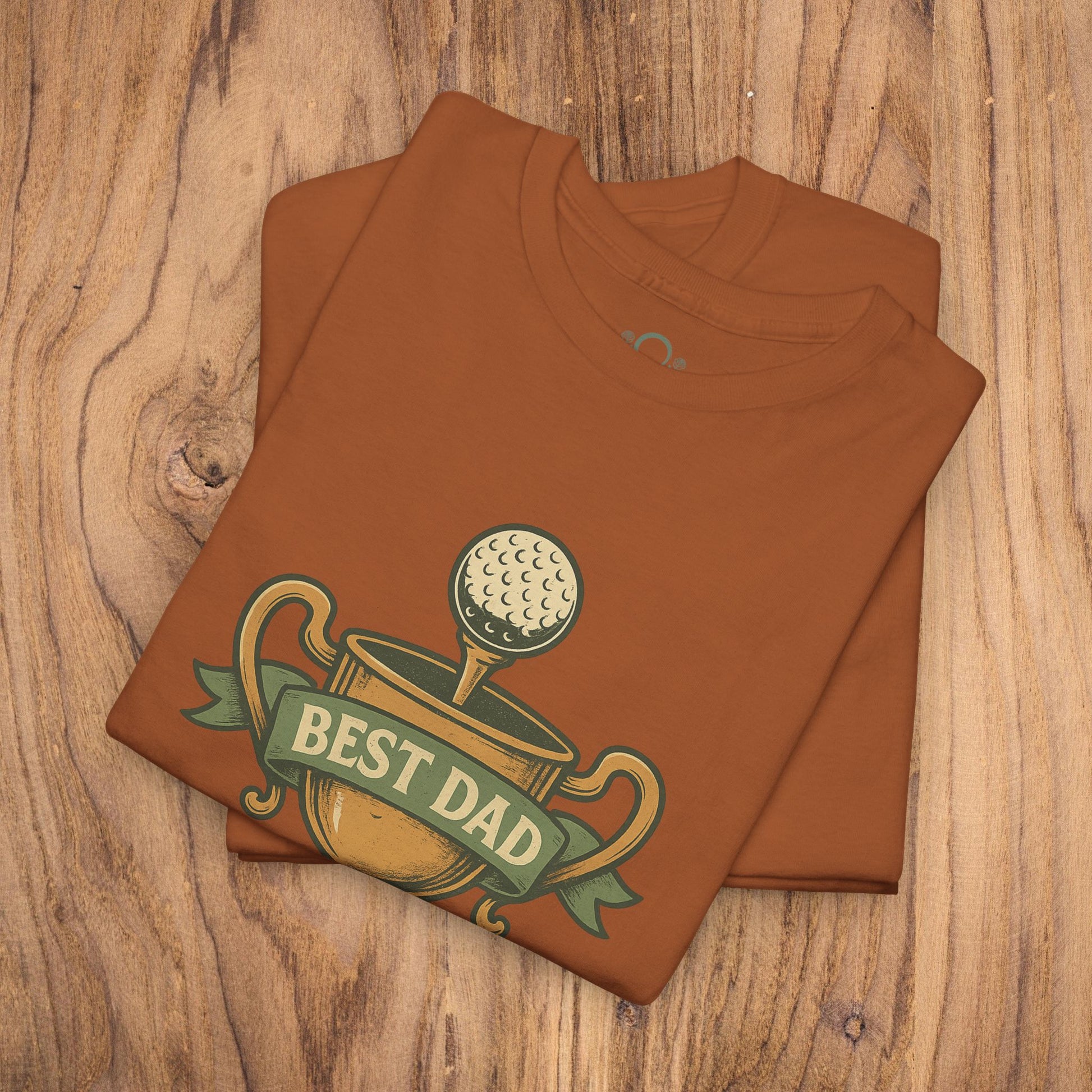 Best Dad Trophy T-Shirt displayed on a wooden surface, featuring an eye-catching print with a golf ball and the words 'Best Dad', made from soft cotton for comfort and durability.