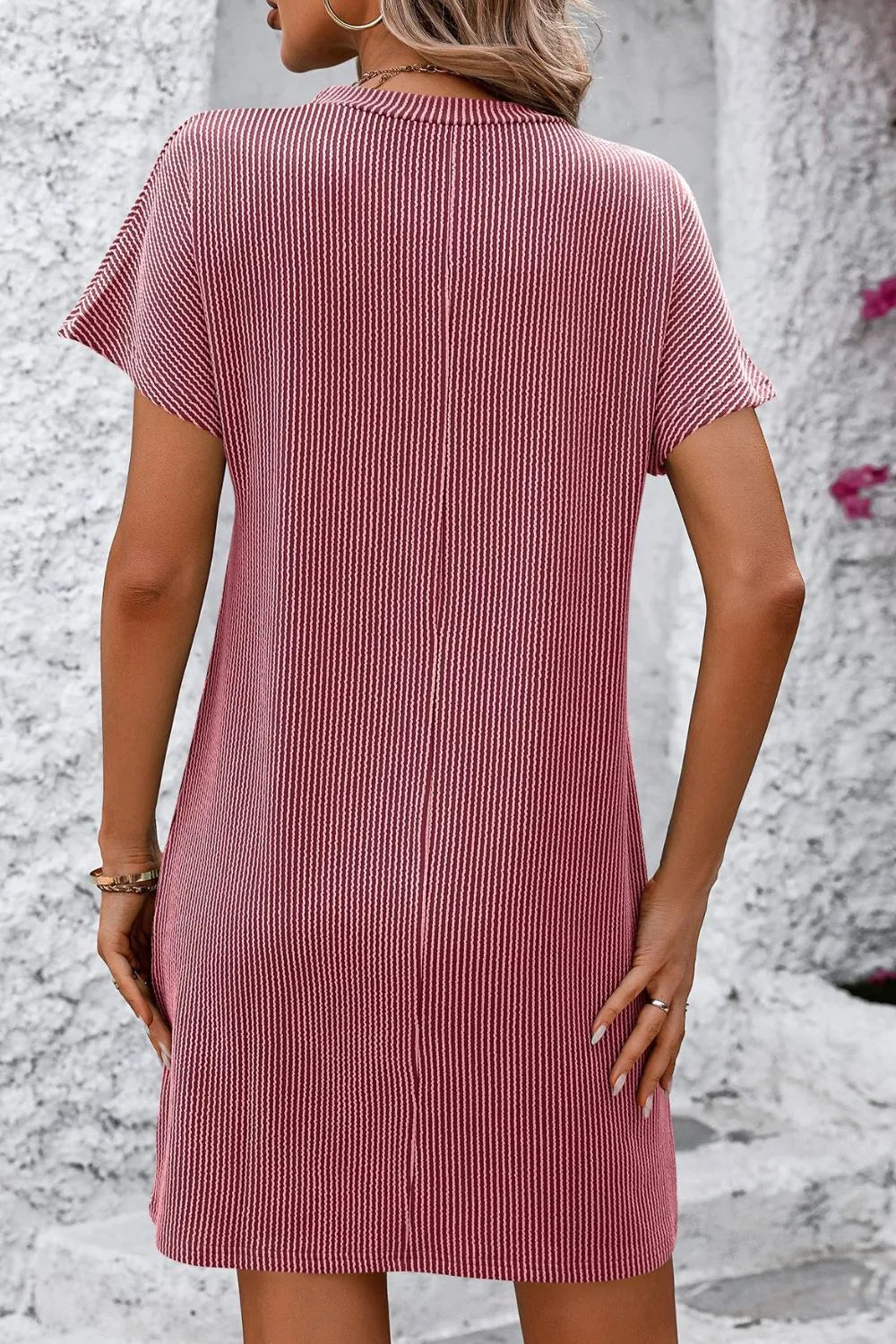 Back view of the Mandy Ribbed Striped Mini Tee Dress with Pockets in pink, highlighting the smooth silhouette and comfortable fit of the short sleeve design.