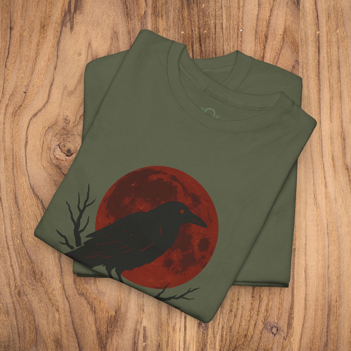 Gothic Raven T-Shirt displaying a raven against a vibrant red moon, ideal for Halloween attire. Crafted with heavy cotton, this unique spooky gift fits perfectly into casual fall fashion.