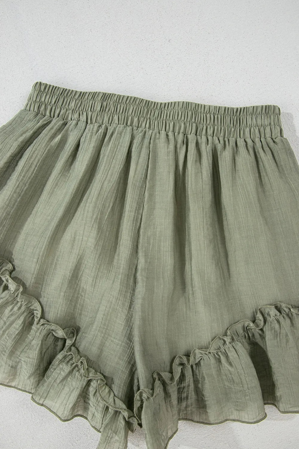 Textured Tie Waist Ruffle Hem Shorts in soft green fabric featuring a frill hem design, perfect for a stylish summer look.