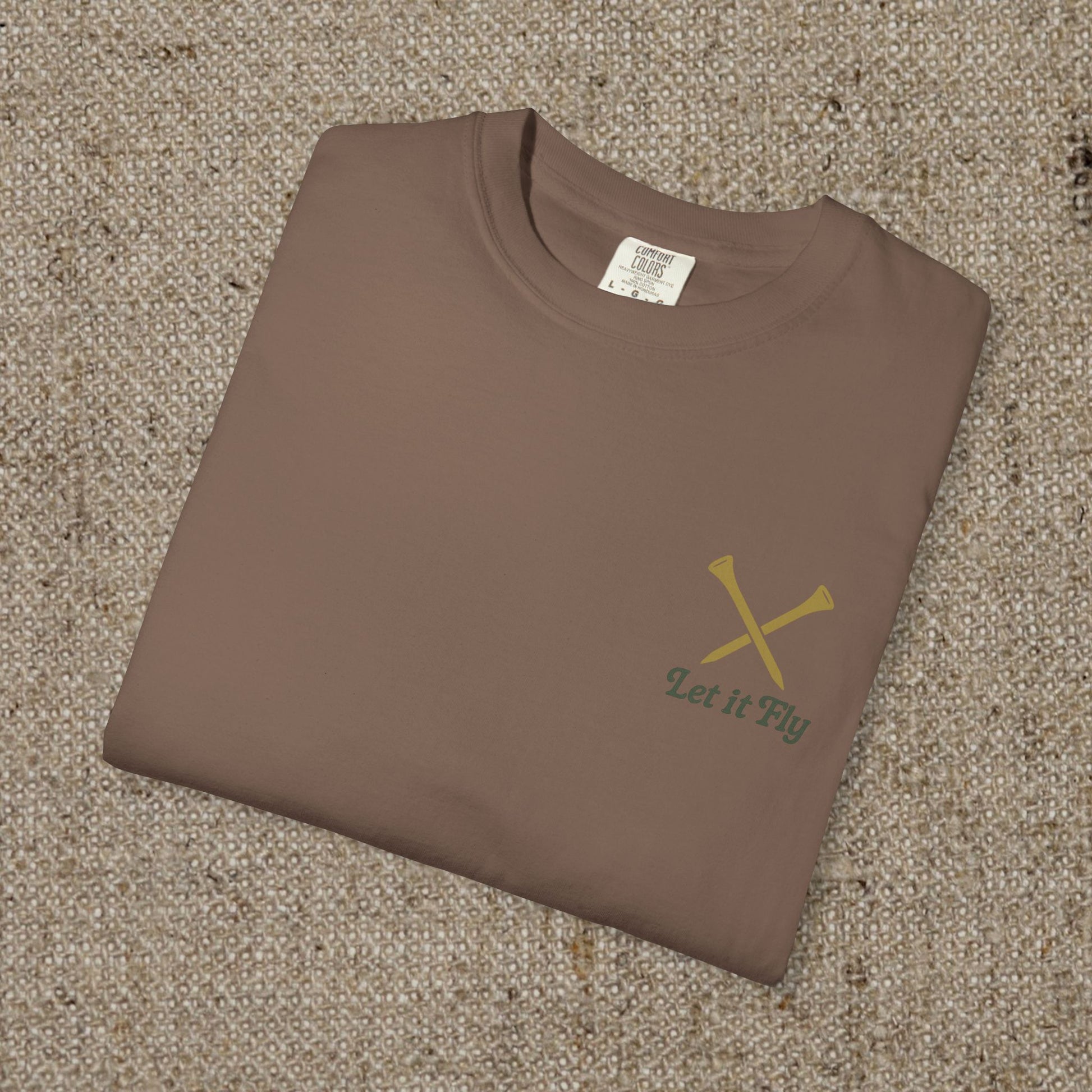 Folded Tee It High Let It Fly Graphic Tee in brown, featuring crossed golf clubs on the chest. A great choice for casual wear.