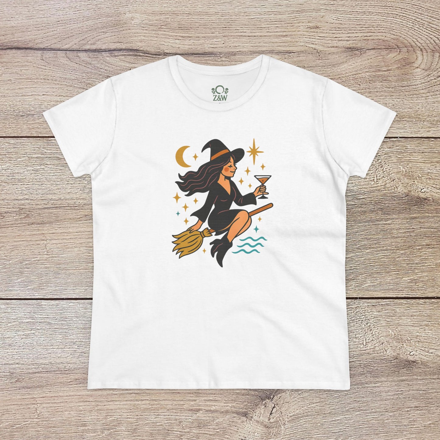Witchy Night Out Tee featuring a stylish illustration of a witch flying on a broomstick with an hourglass, set against a cosmic backdrop, made from 100% cotton and ethically produced.