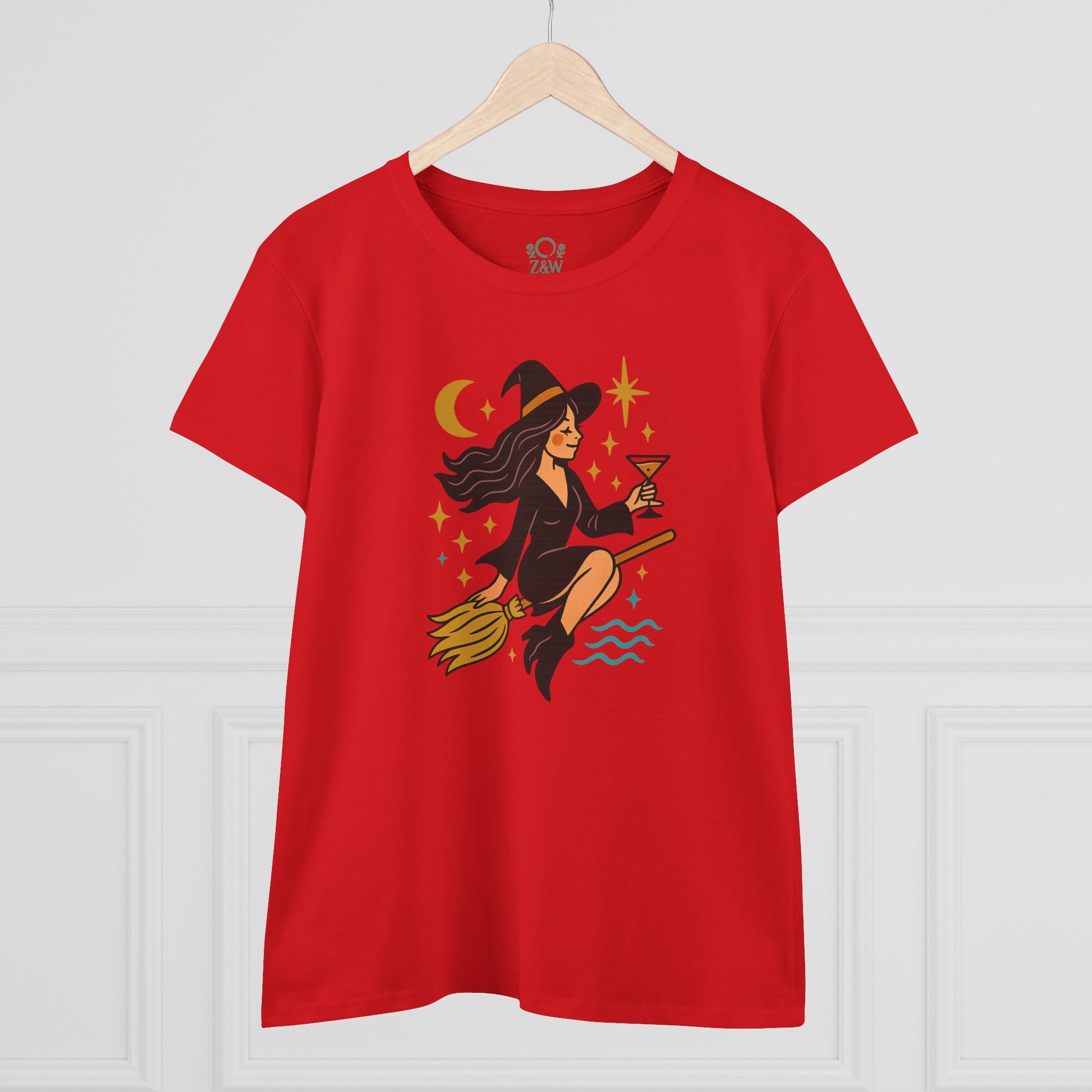 Witchy Night Out Tee in vibrant red featuring a witch with a cocktail, styled on a wooden hanger for a fashion-forward look.