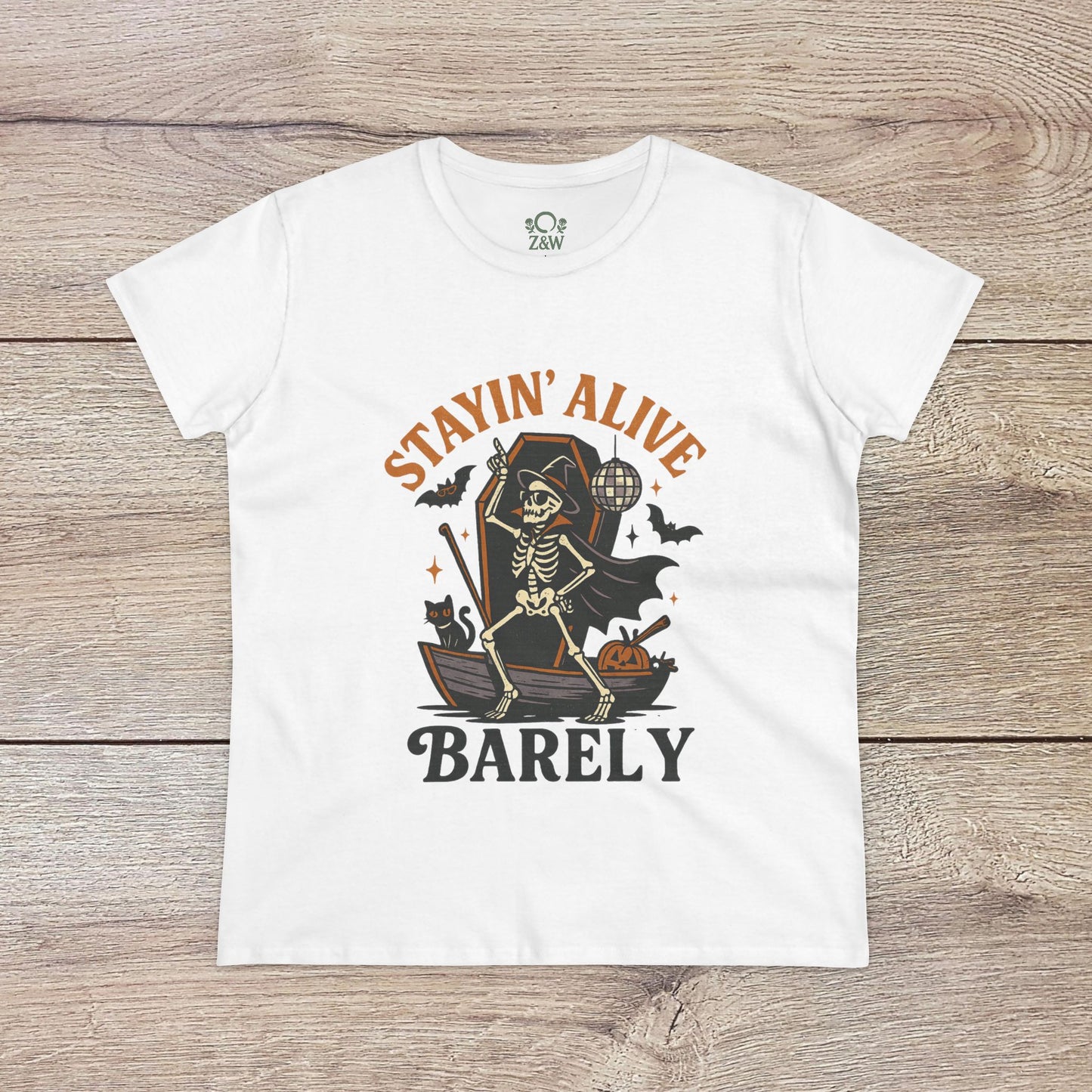 Stayin’ Alive T-Shirt in white showcasing a skeleton graphic and the humorous phrase 'BARELY', perfect for Halloween celebrations or casual wear.