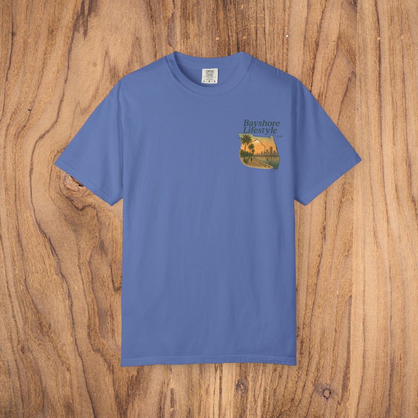 Bayshore Lifestyle Tee in light blue color, featuring a palm tree graphic, made from 100% cotton lightweight fabric with a ribbed neck. Available in sizes XS-5XL.