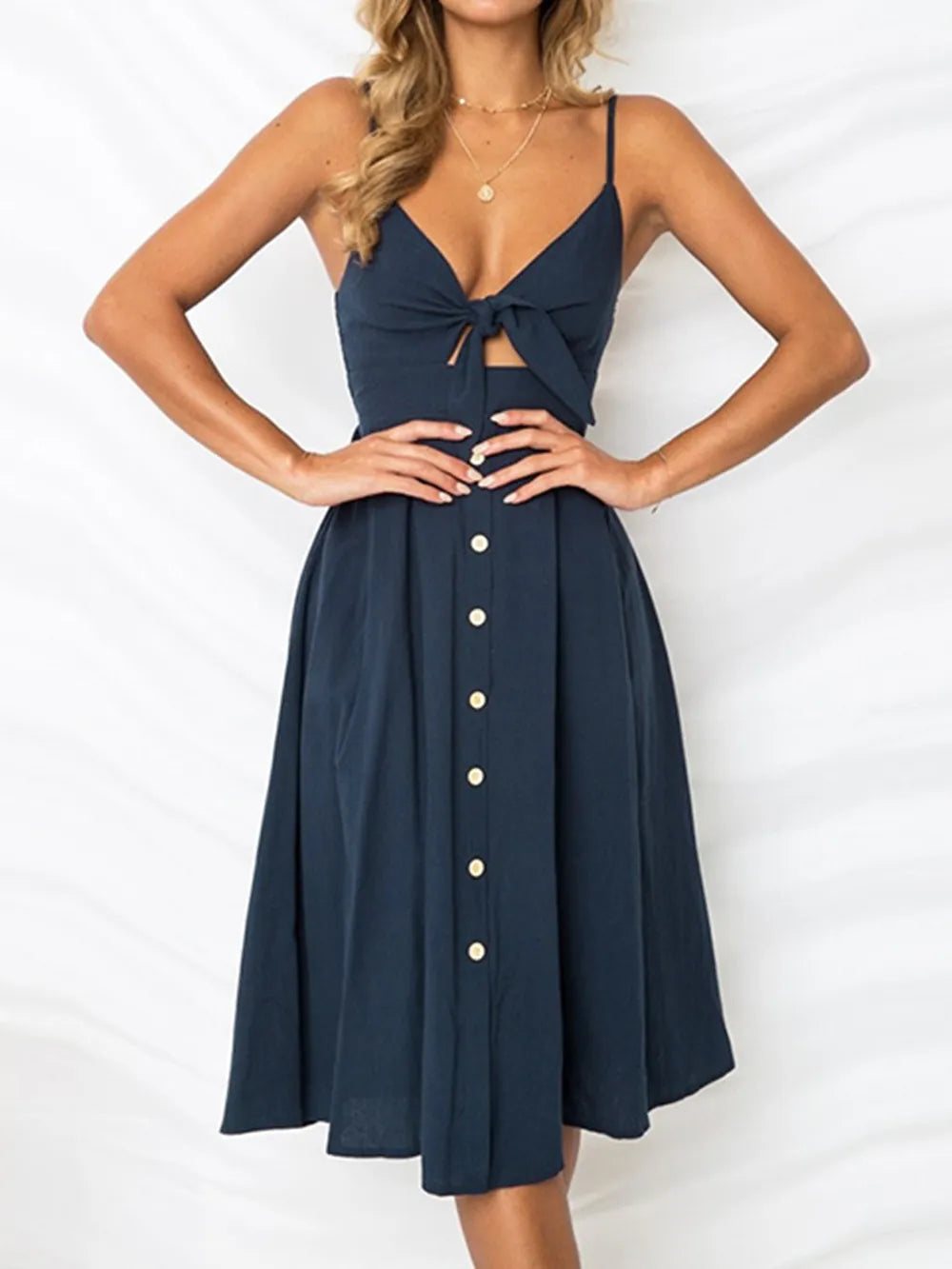 Cutout Smocked Sweetheart Neck Cami Dress with Decorative Button and Opaque Design, displayed front-facing on a model, featuring a stylish tied detail and buttons down the front.