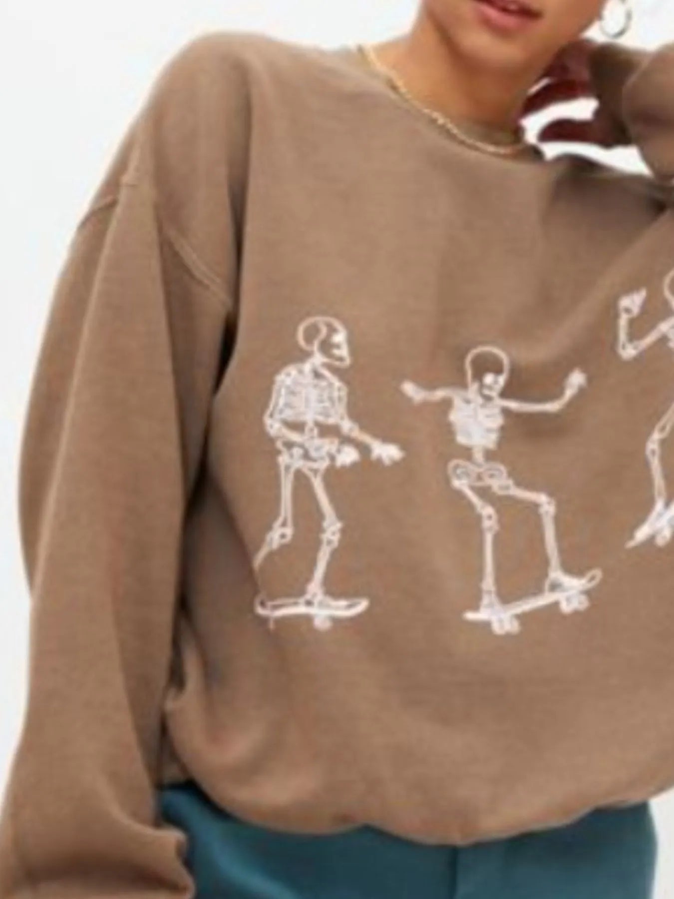 Close-up of the Oversized Skeleton Graphic Sweatshirt for Women, highlighting the fun skeleton motifs, made from 100% polyester for a comfortable and slightly stretchy wear.