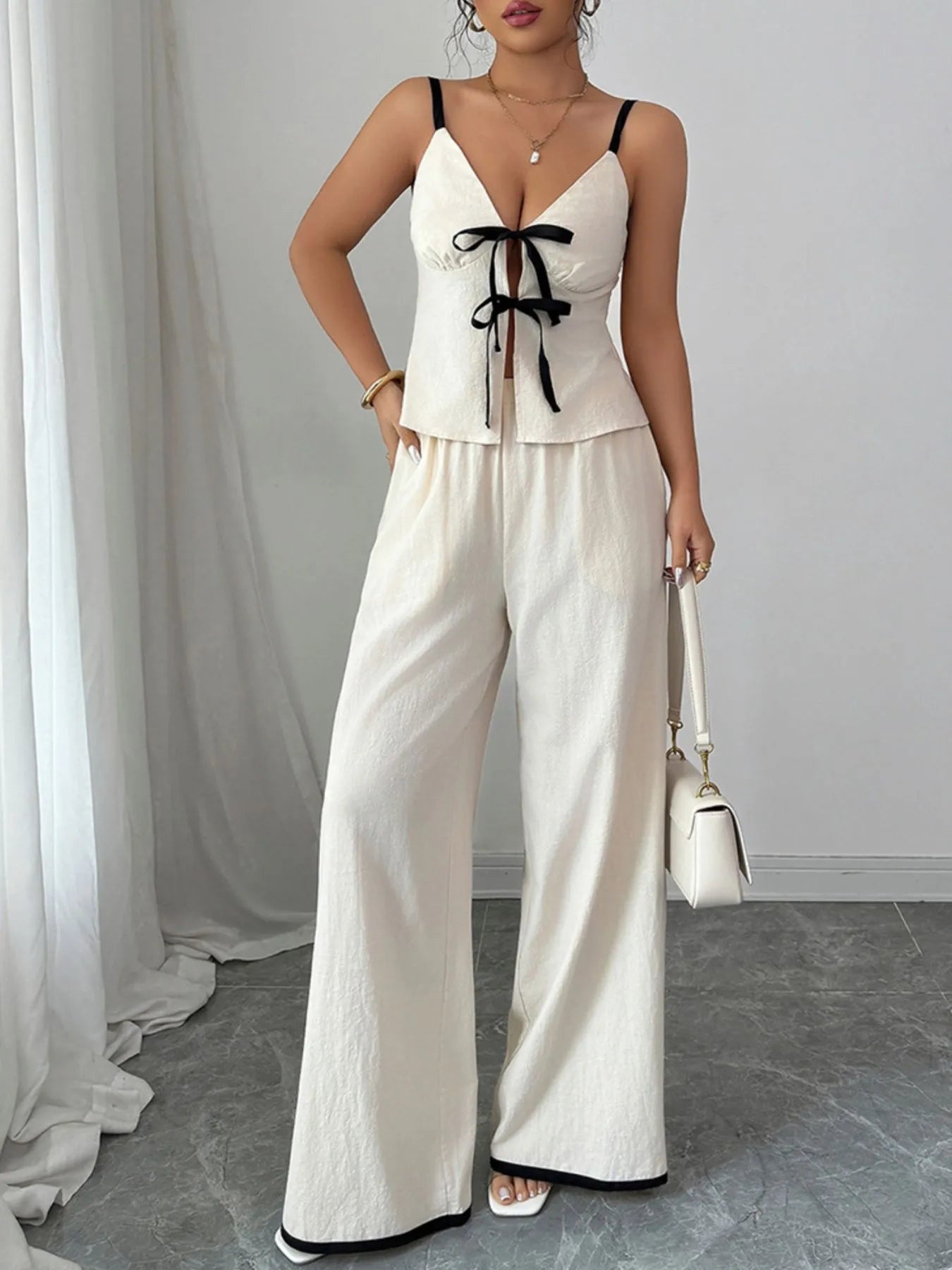 Trendy 2-Piece Tie Front Cami and Pocketed Pants Set showcased on a model, made of 100% cotton with no stretch, featuring a stylish tie front and elegant wide-leg pants.