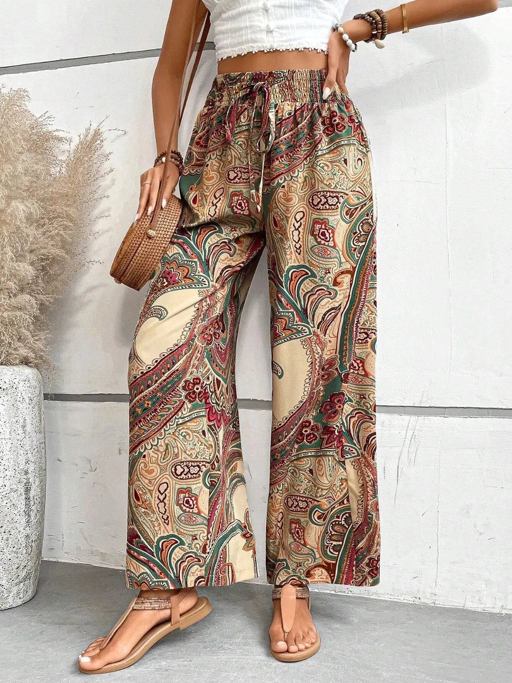 Trendy Printed Wide Leg Pants with Tied Detail showcased in a side view, featuring a vibrant paisley pattern and 100% opaque polyester fabric, ideal for casual outings or summer events.