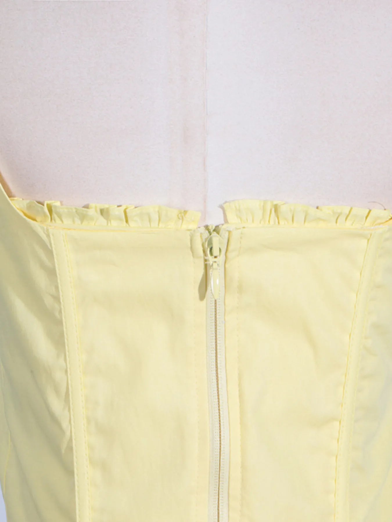 Close-up of the zip back detail of the Trendy Slit Sleeveless Midi Dress with Zip Back in yellow, emphasizing the stylish zip closure.