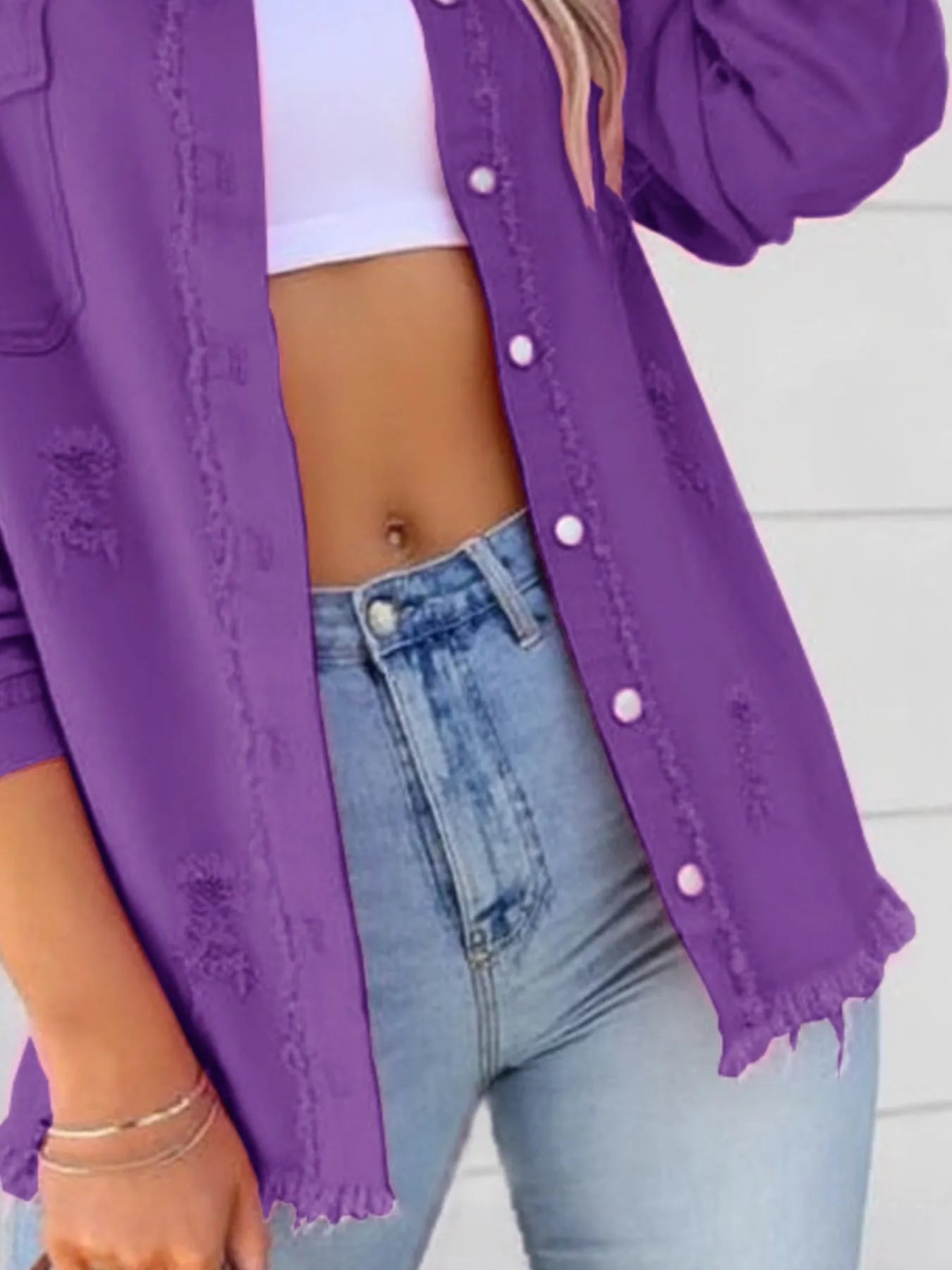Detail shot of the oversized distressed denim jacket with frayed edges and buttoned pockets, emphasizing the stylish elements of this trendy casual outerwear.