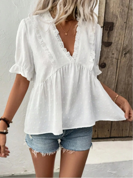 Stylish Swiss Dot Ruffled V-Neck Blouse with Flounce Sleeves, featuring a babydoll fit, paired with denim shorts for a chic summer look.