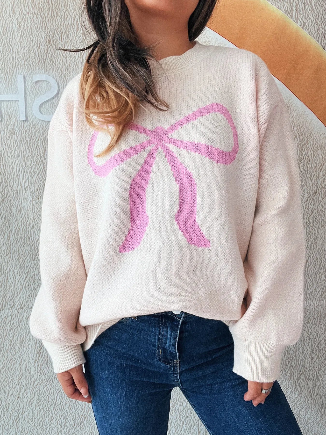 Stylish Bow Pattern Casual Long Sleeve Sweater for Effortless Everyday Wear, highlighted by a pink bow motif, worn casually with jeans for a trendy look.