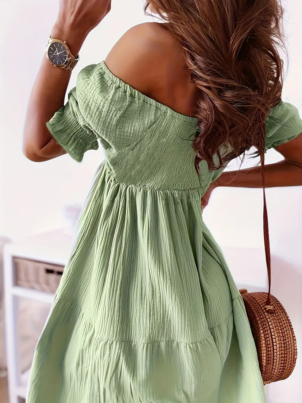 Back view of a model in a green full size ruffled off-shoulder dress with short sleeves, emphasizing the ruched design and flattering fit.