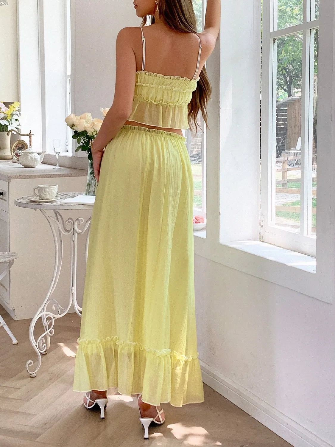 Back view of model showcasing the Two-Piece Frill Square Neck Cami and Ruched Skirt Set in Stretchy Lyocell Blend, highlighting the elegant yellow color and frill details.