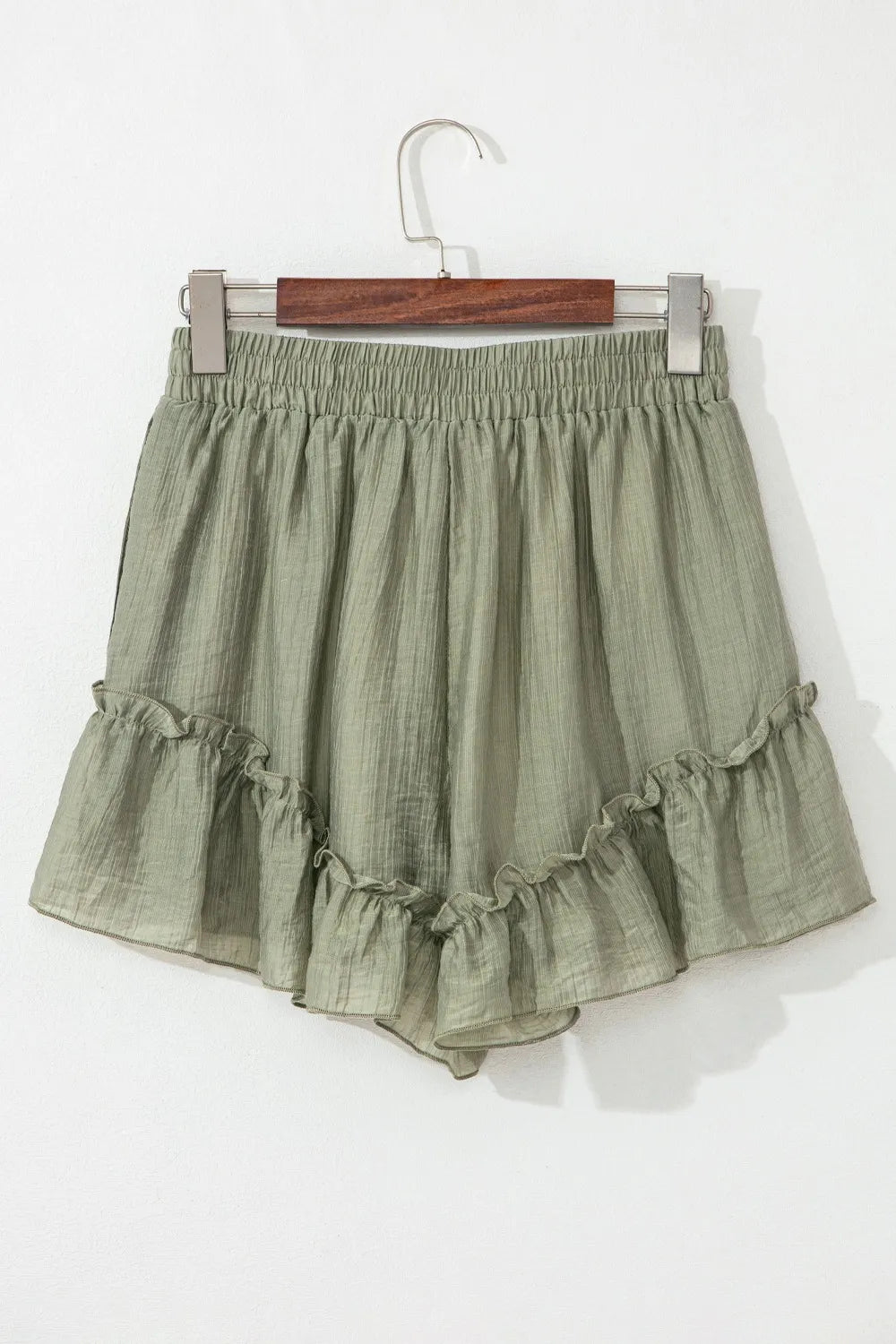 Back view of the Textured Tie Waist Ruffle Hem Shorts in olive green, featuring a loose, comfortable fit and playful ruffle design.
