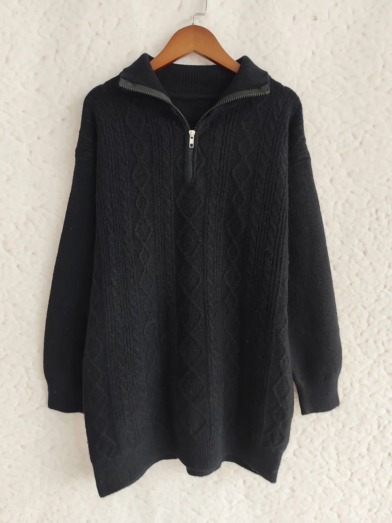 Cozy Cable-Knit Texture Zip Collar Long Sleeve Sweater in black, displayed on a hanger, emphasizing its elegant style.